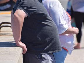 Imagem foca na região do abdômen de duas pessoas obesas sem mostrar seus rostos