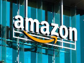 Letreiro com o nome 'Amazon' em letras brancas e o símbolo da empresa em amarelo na fachada