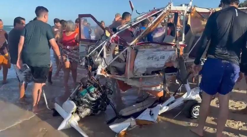 Banhistas observam avião destroçado em praia no Aquiraz