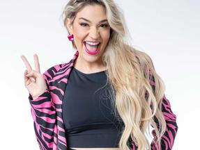 Marília Miranda, participante do 'Big Brother Brasil 23', sorrindo e usando casaco rosa