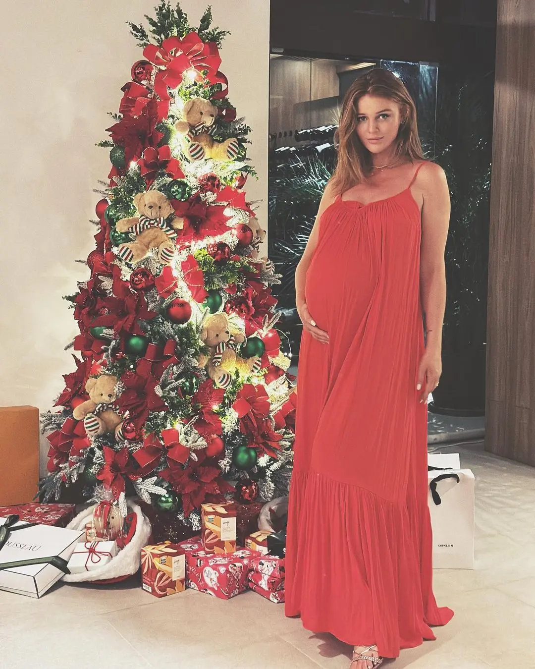 Cintia Dicker grávida ao lado da árvore de Natal