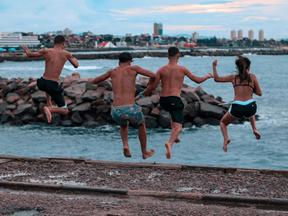 Jovens saltam de ponte no Poço da Draga em direção ao mar