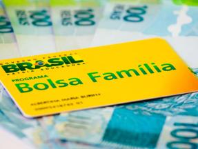 Cartão do Bolsa Família sobre cédulas de R$ 100