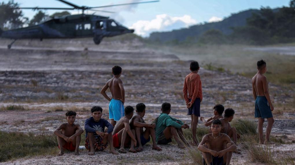 Indígenas da etnia yanomami olham helicóptero