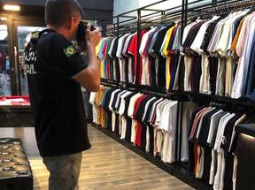 Policial fotografa roupas falsificadas em loja