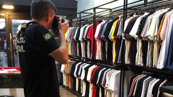 Policial fotografa roupas falsificadas em loja