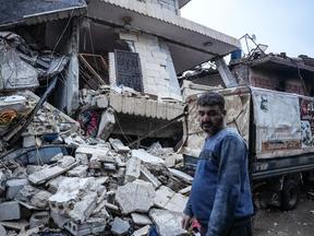 Um morador fica em frente a um prédio que desabou após um terremoto na cidade de Jandaris, no interior da cidade de Afrin, no noroeste da Síria, na parte controlada pelos rebeldes da província de Aleppo, em 6 de fevereiro de 2023