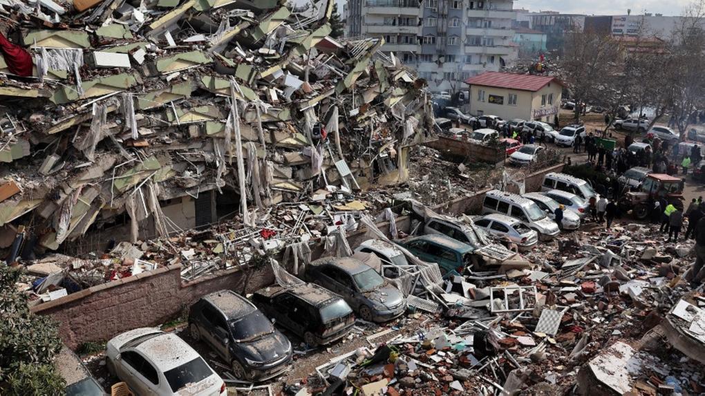 Equipes de resgate e civis procuram sobreviventes sob os escombros de prédios desabados em Kahramanmaras, perto do epicentro do terremoto, um dia após um terremoto de magnitude 7,8 atingir o sudeste do país, em 7 de fevereiro de 2023