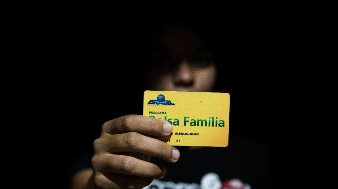 beneficiário segurando cartão do bolsa família