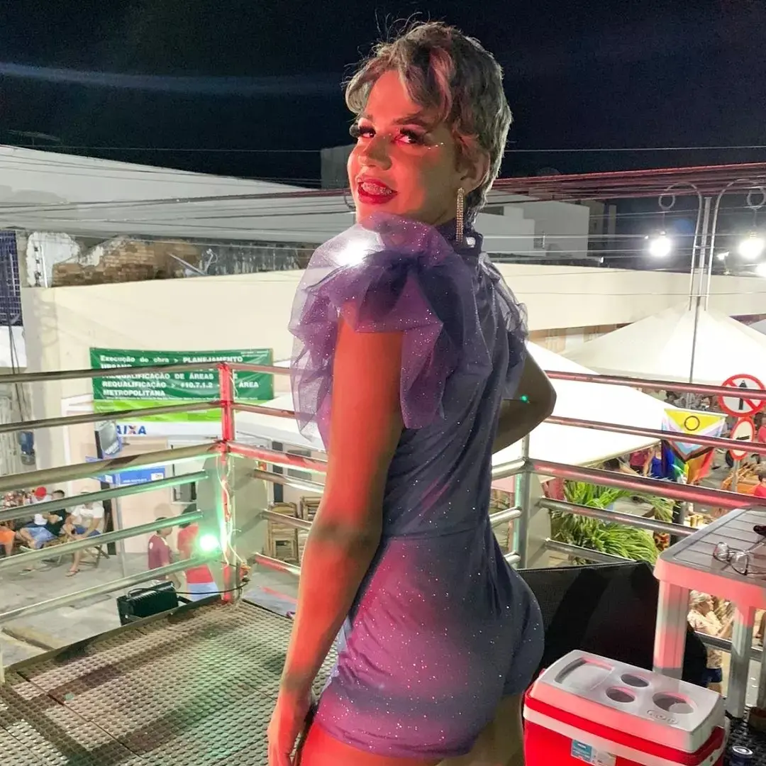 Jhully Carla sentada em uma cadeira sorrindo