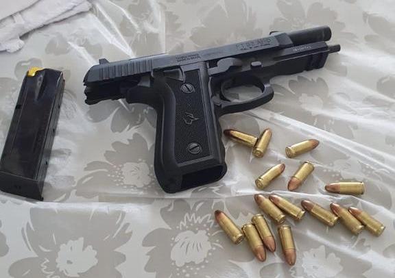 Arma e munições em cima de uma cama