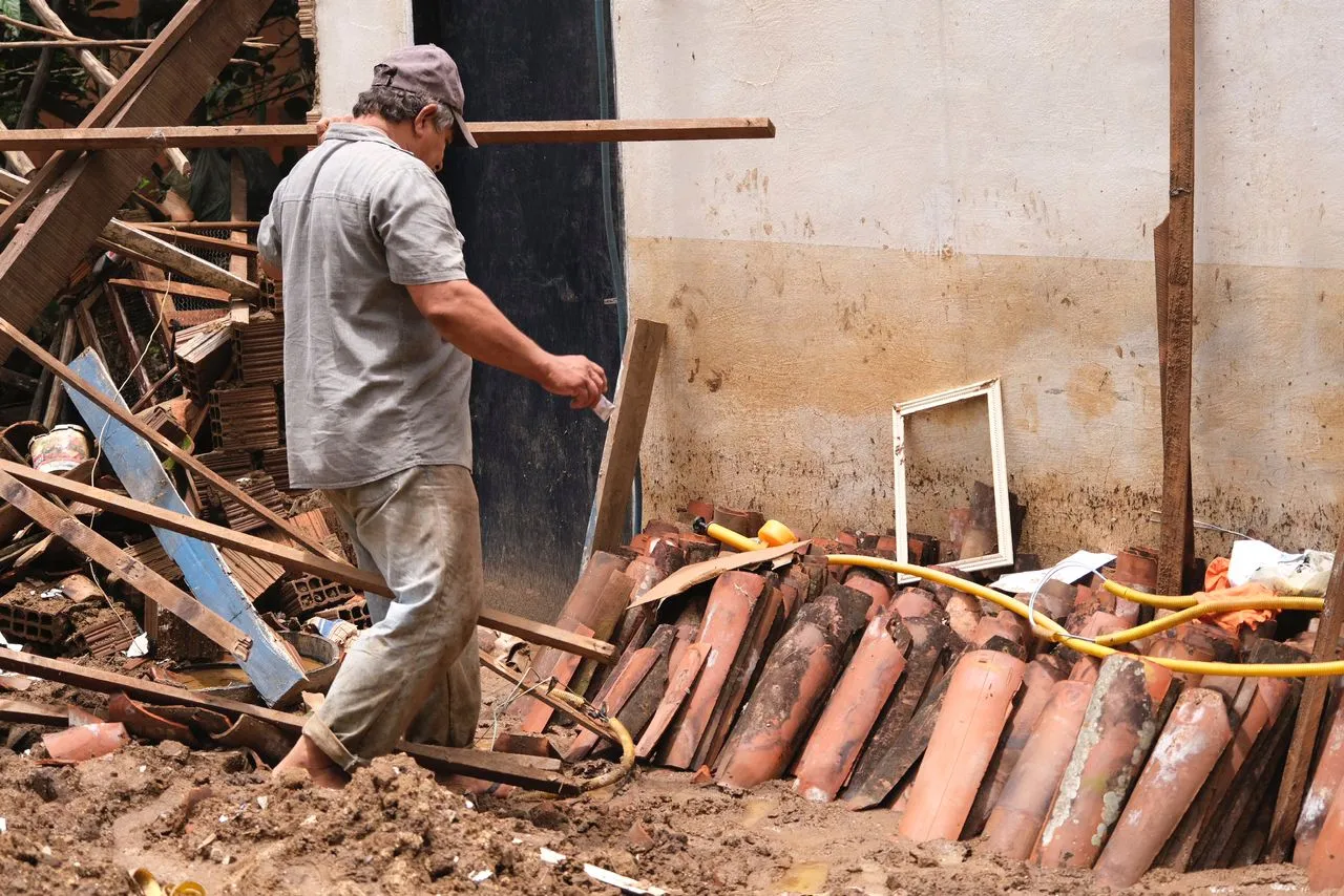 Agricultor checa o que restou da casa após as chuvas