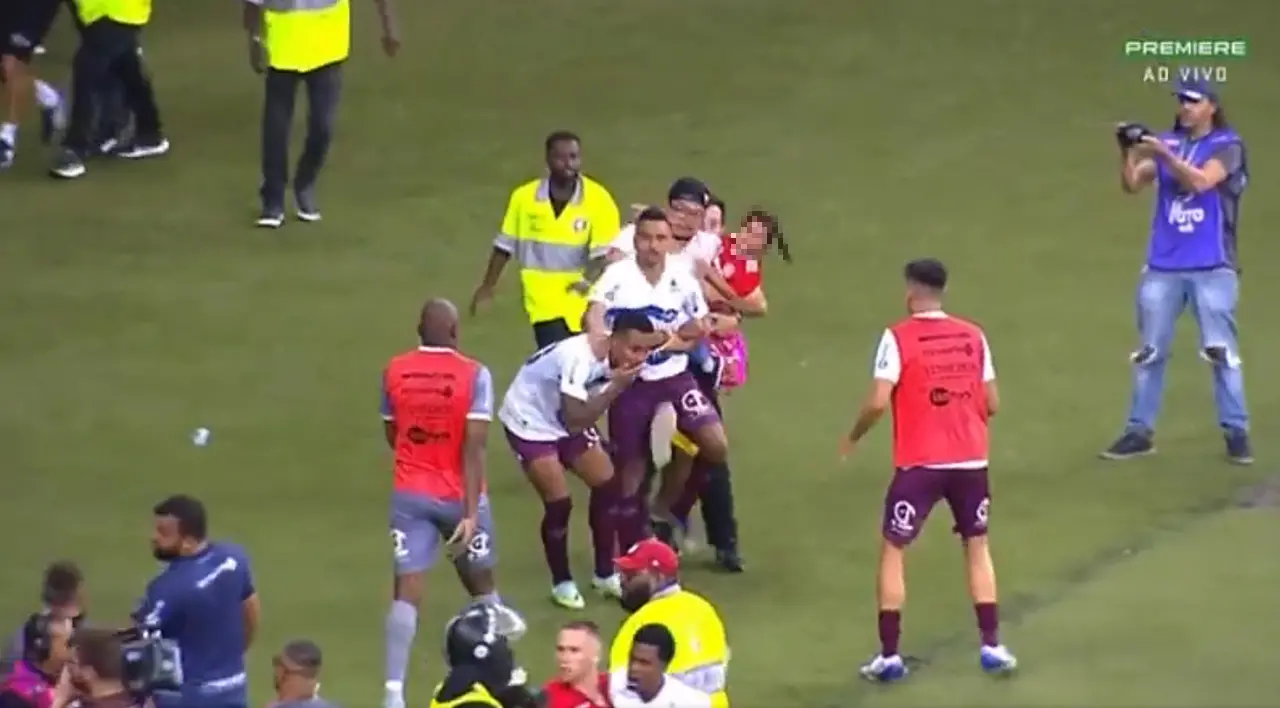 Imagem da notícia: Torcedor invade campo com criança no colo e agride jogador em Internacional x Caxias; veja vídeo