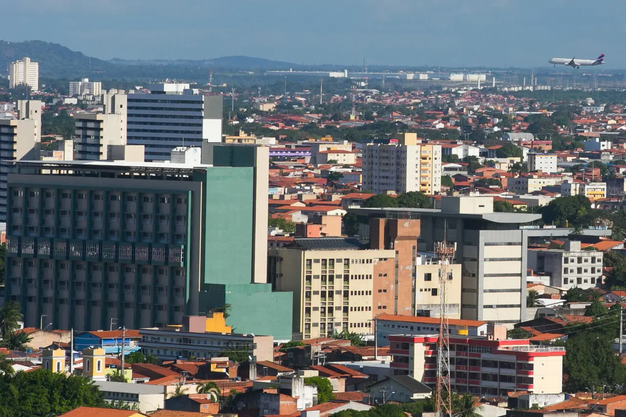 Vista aérea de fortaleza, com prédios e um avião no céu