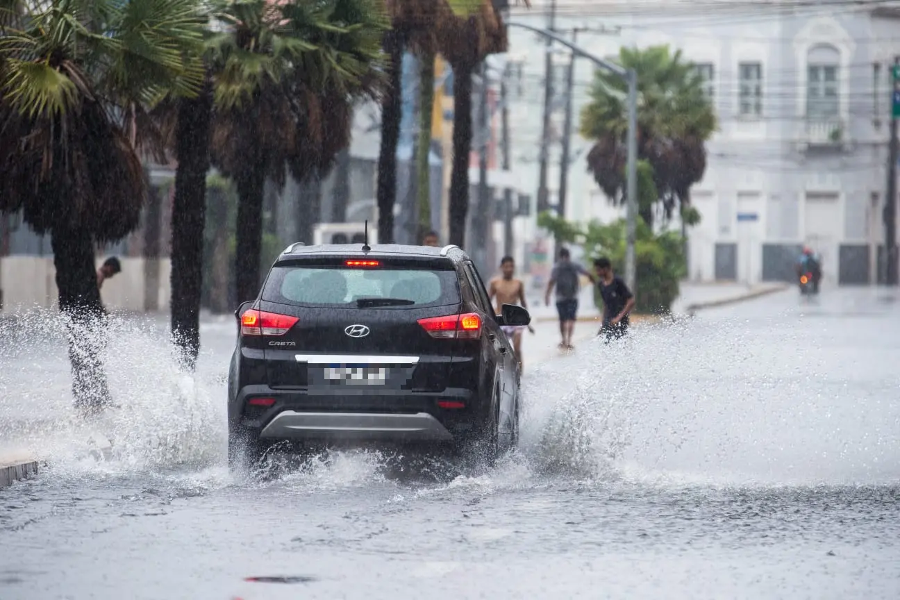 carro passando em avenida alagada