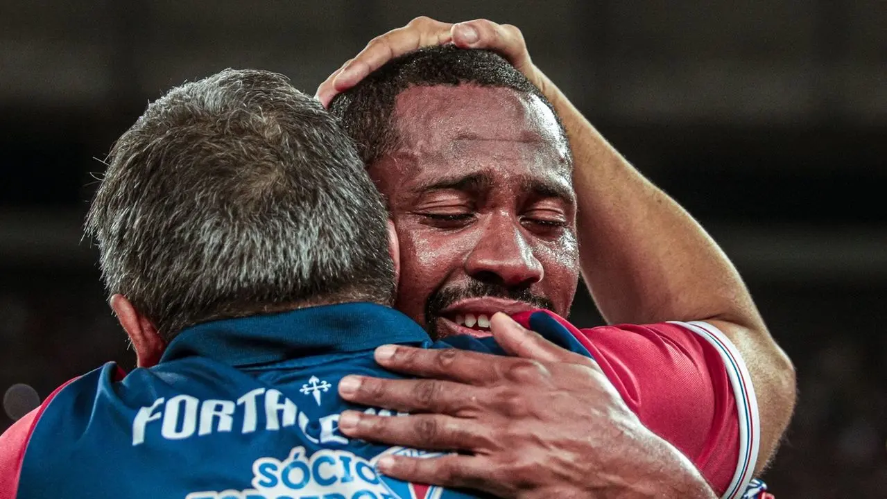 Imagem mostra técnico de futebol Vojvoda e o lateral Tinga em abraço