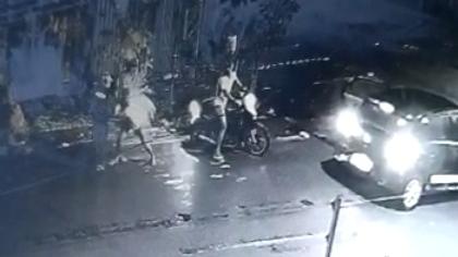 Um vídeo de câmera de segurança mostra a policial, pronta para sair em uma motocicleta, ser surpreendida por criminosos que passavam em um carro