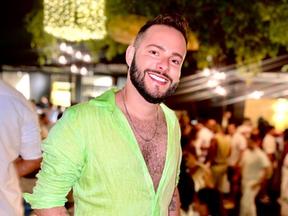 maquiador Julyer Rodrigues está sorrindo e de camisa verde