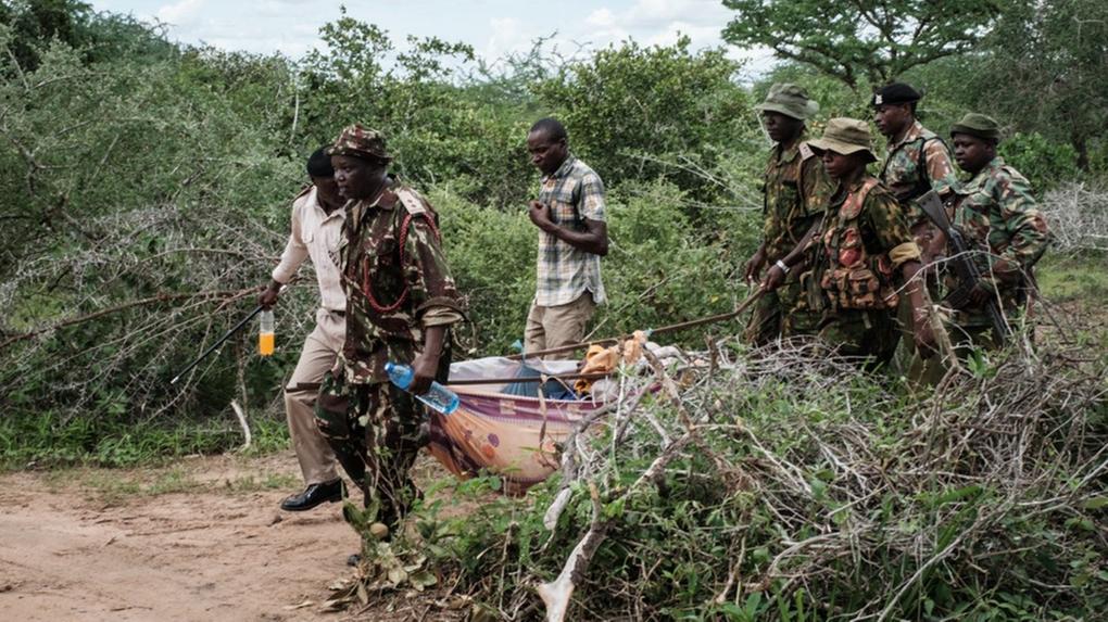 Homens carregam corpo de vítima de massacre no Quênia