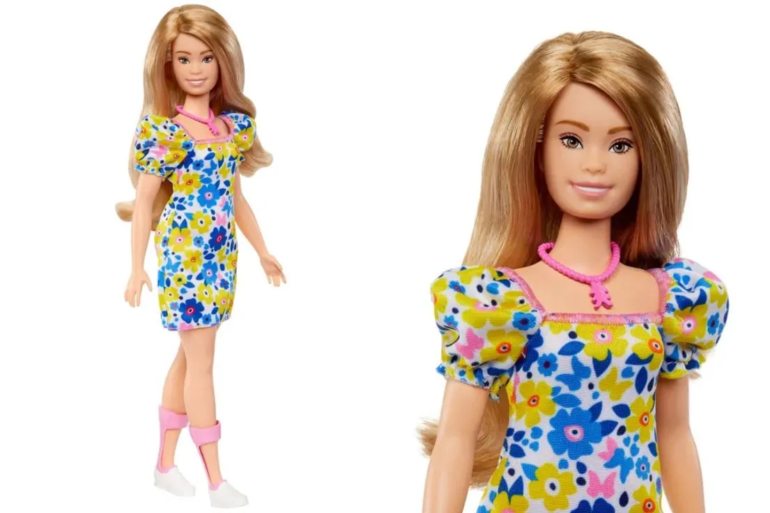 A boneca vem vestida em tons de amarelo e azul, cores que remetem a campanhas de conscientização da síndrome de Down