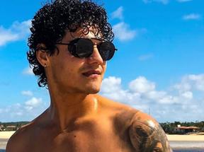 Influenciador Brendo Yan usando óculos de sol na praia