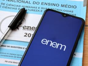 Prova azul do Enem e um celular aberto no aplicativo do exame