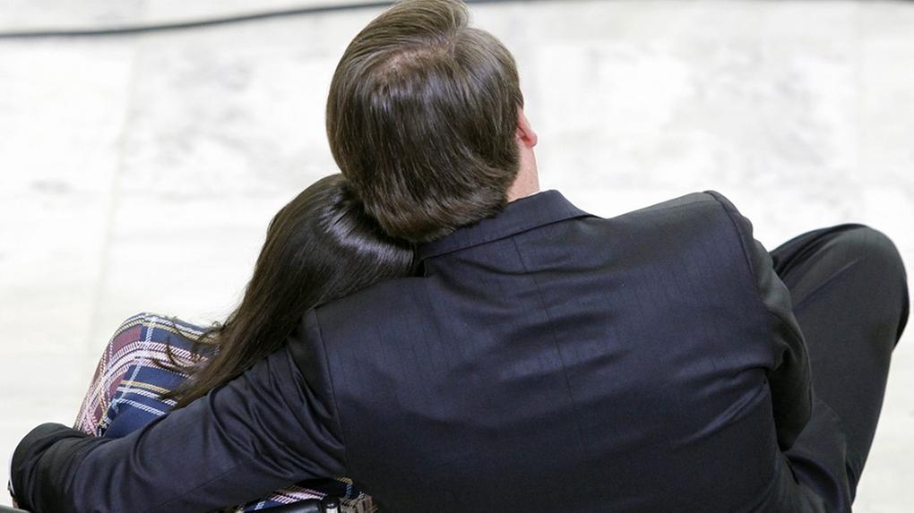 Bolsonaro e Laura estão abraçados, de costas. Laura repousa a cabeça no ombro do pai
