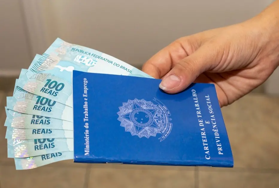 Carteira de trabalho com notas de cem dentro