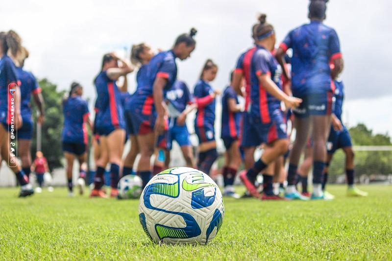 imagem mostra jogadoras de futebol e técnico