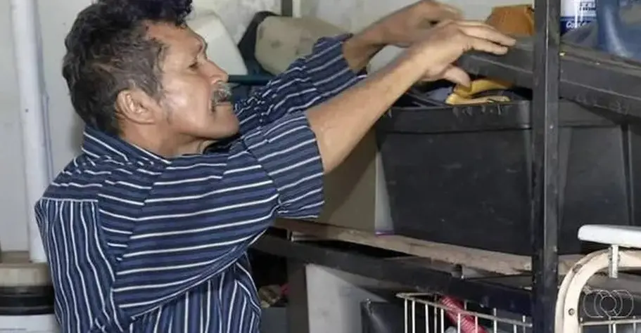 Antônio é um homem idoso, de bigode e cabelo grisalhos, e está mexendo em caixas