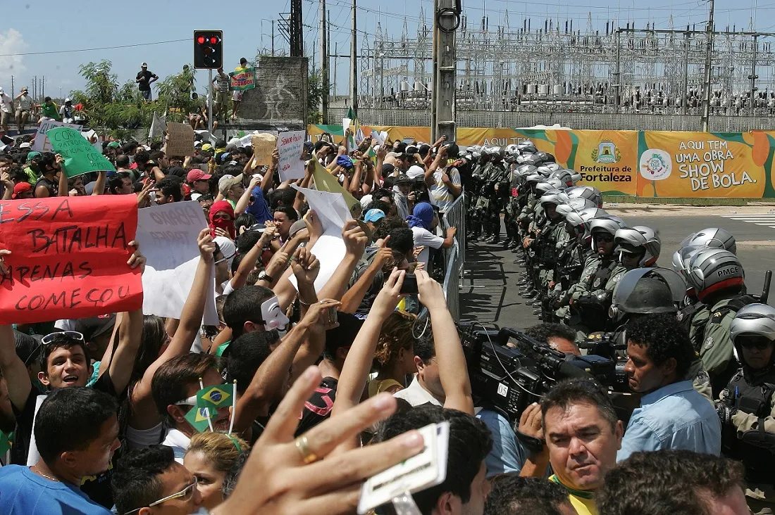 O momento em que manifestantes encontram a barreira policial que buscava impedir que eles se aproximassem da Arena Castelão