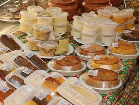 Mesa com produtos juninos como bolo e pamonha