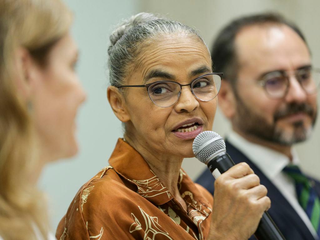 Marina Silva segura microfone ao falar em evento