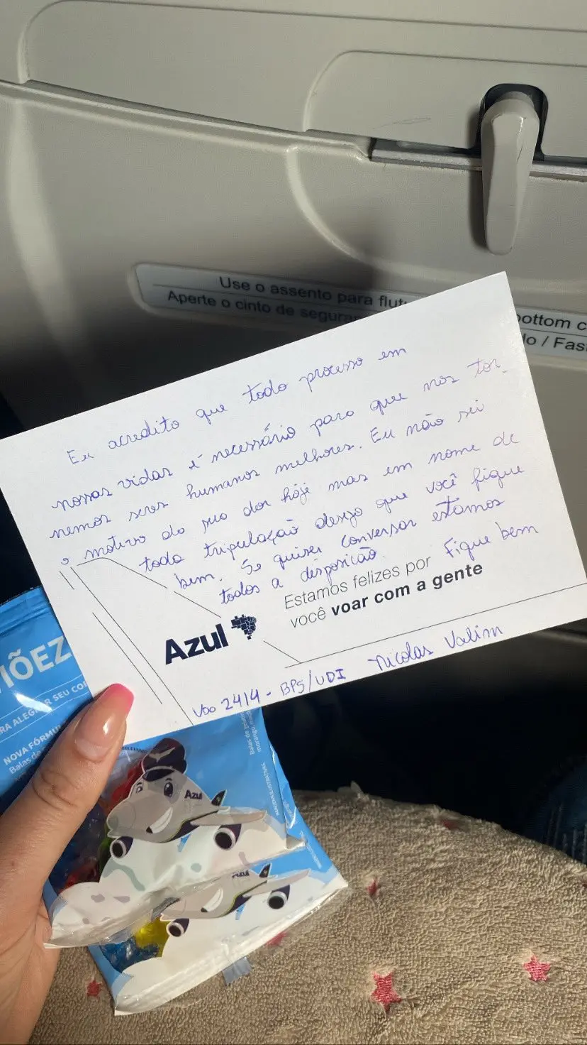 Passageira recebe bilhete de comissário de bordo