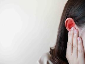 mulher com dedo no ouvido