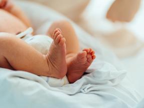 Pés de bebê recém-nascido em cobertor branco no hospital