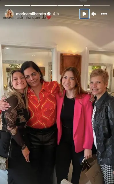 as gemeas e a madrinha e a mãe, abraçadas