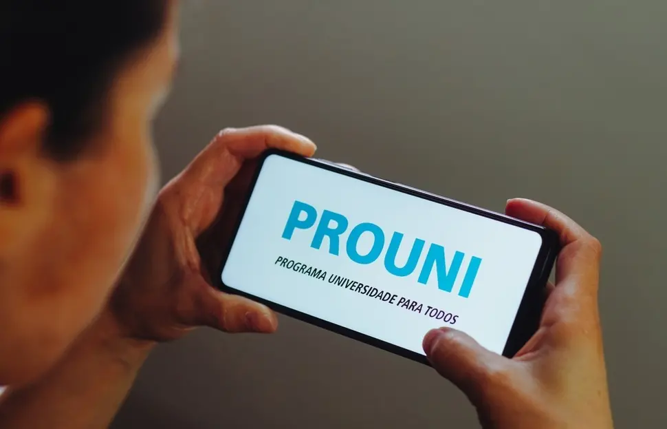 Pessoa segurando celular aberto no aplicativo do Prouni