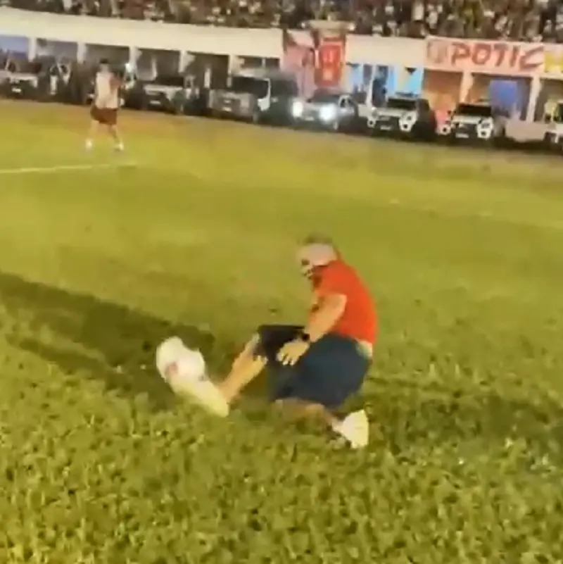 Imagem mostra homem caído em gramado