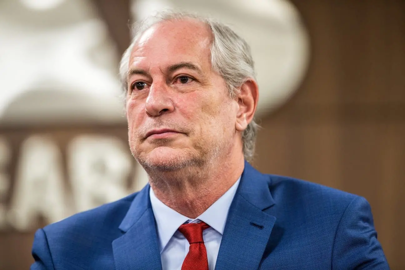 Ciro Gomes é um homem branco, de cabelo branco. Ele está de terno azul e com expressão séria
