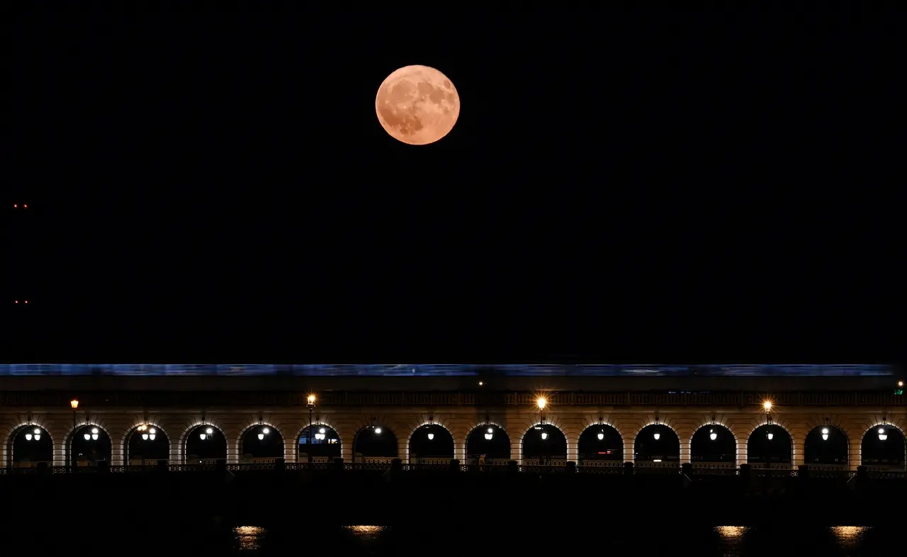 Esta fotografia tirada em Paris em 3 de julho de 2023 mostra a superlua de julho, conhecida como 'Superlua dos Cervos', com a 'Pont de Bercy' em primeiro plano.
