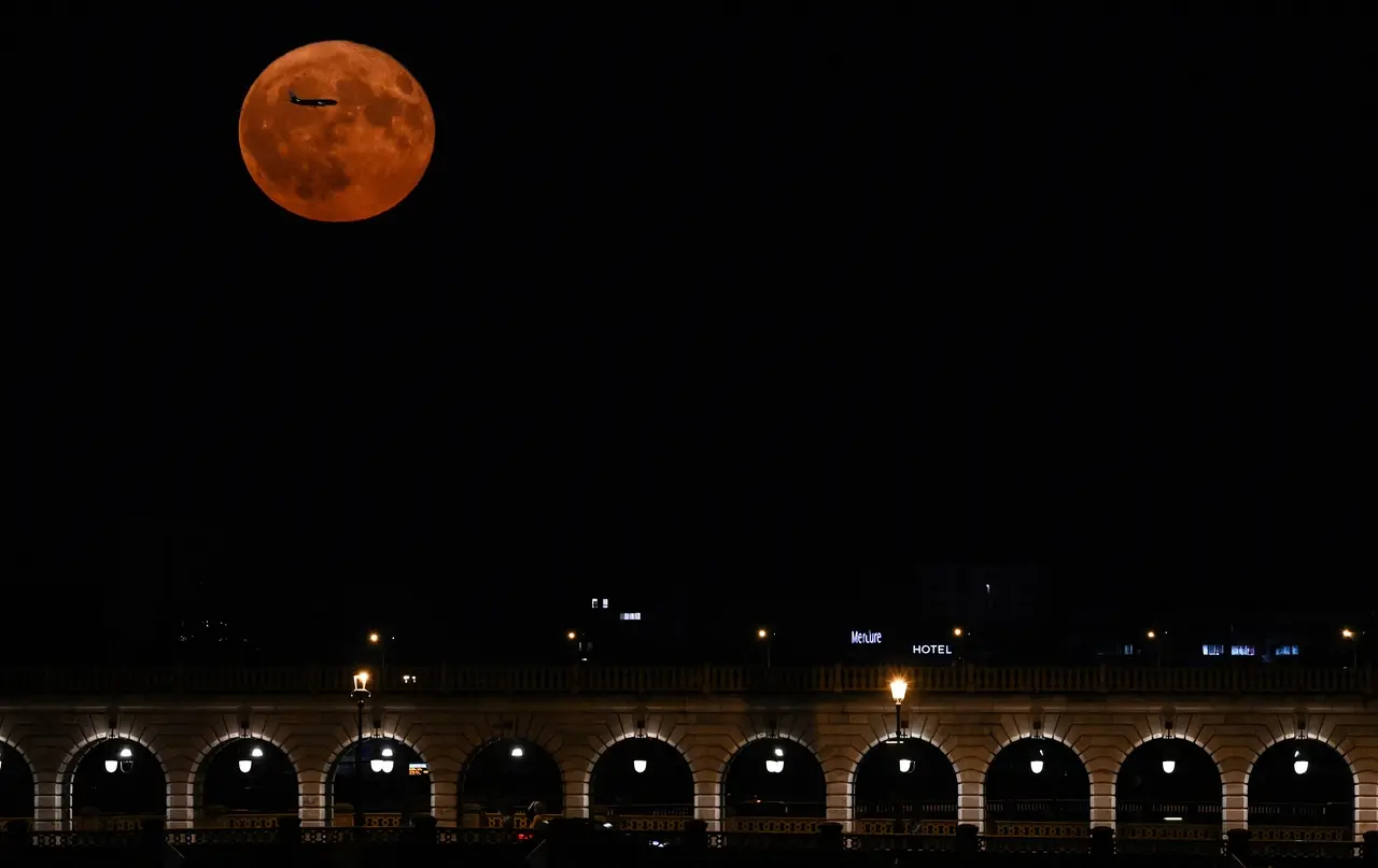 Esta fotografia tirada em Paris em 3 de julho de 2023 mostra a superlua de julho, conhecida como 'Superlua dos Cervos', com a 'Pont de Bercy' em primeiro plano.