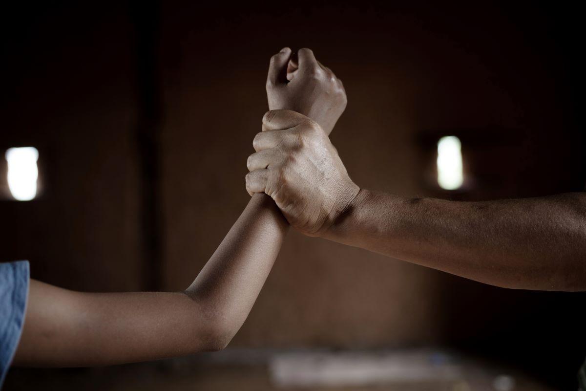 homem pegando na mão de criança