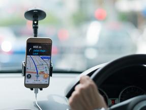 Motorista por aplicativo dirige enquanto olha mapa pelo celular