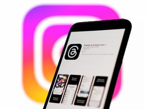 Logotipos de aplicativos Threads vistos em telas com o logotipo do aplicativo do Instagram em segundo plano