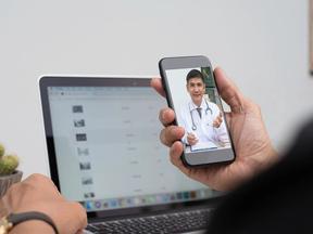 Pessoa segura celular aberto em uma consulta com um médico