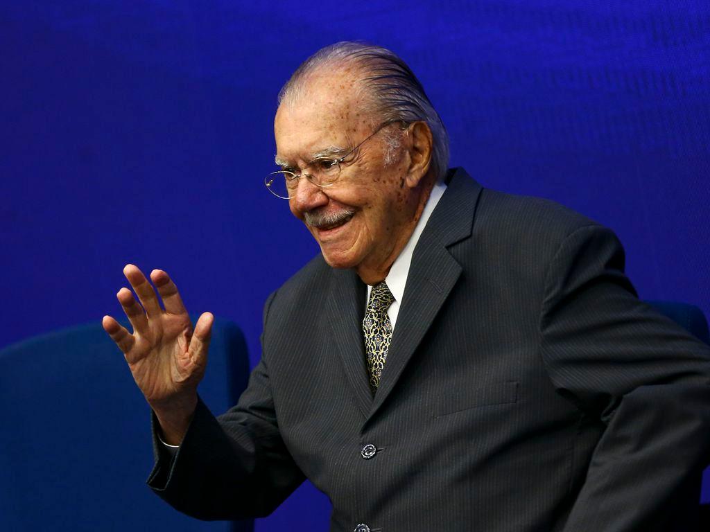 José Sarney é um homem idoso , branco, de bigode grisalho e óculos pequenos, redondos