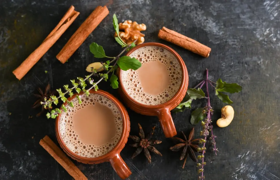 Canecas de café ao lado de paus de canela