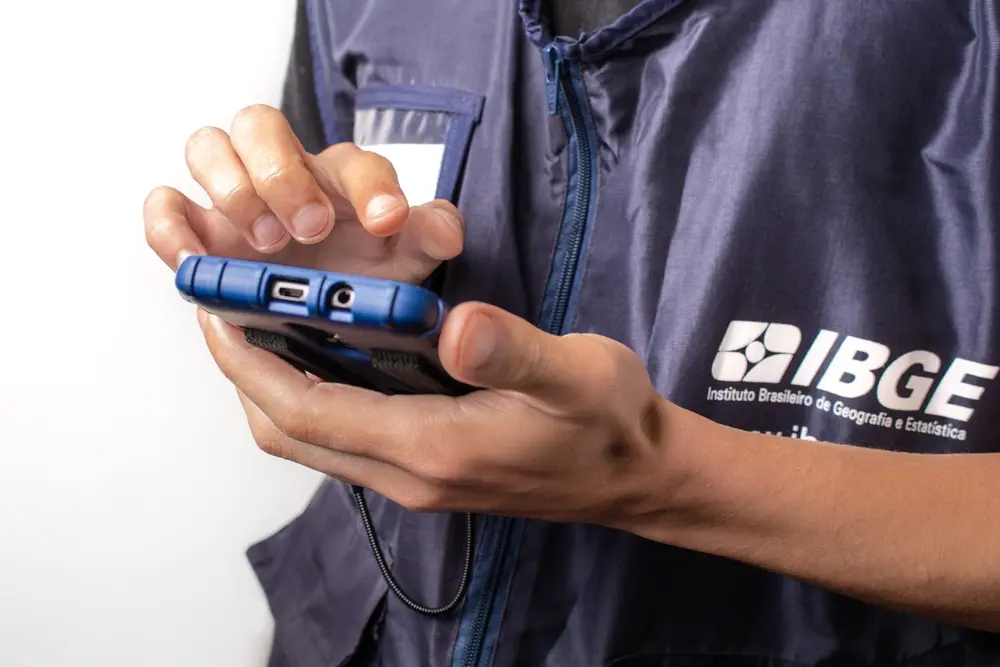 Funcionário do IBGE mexe em aparelho eletrônico