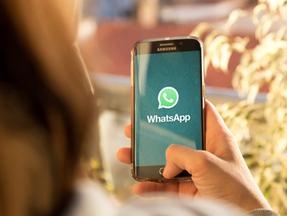 Pessoa acessando o WhatsApp em celular da Samsung